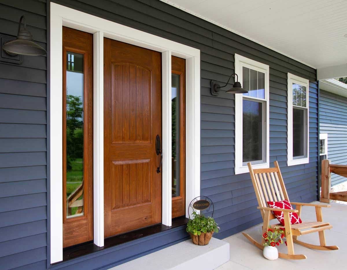 Signet® Knotty Alder 002CP-437 in Caramel Fiberglass Door on blue house